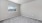 an empty bedroom with a window and a carpet